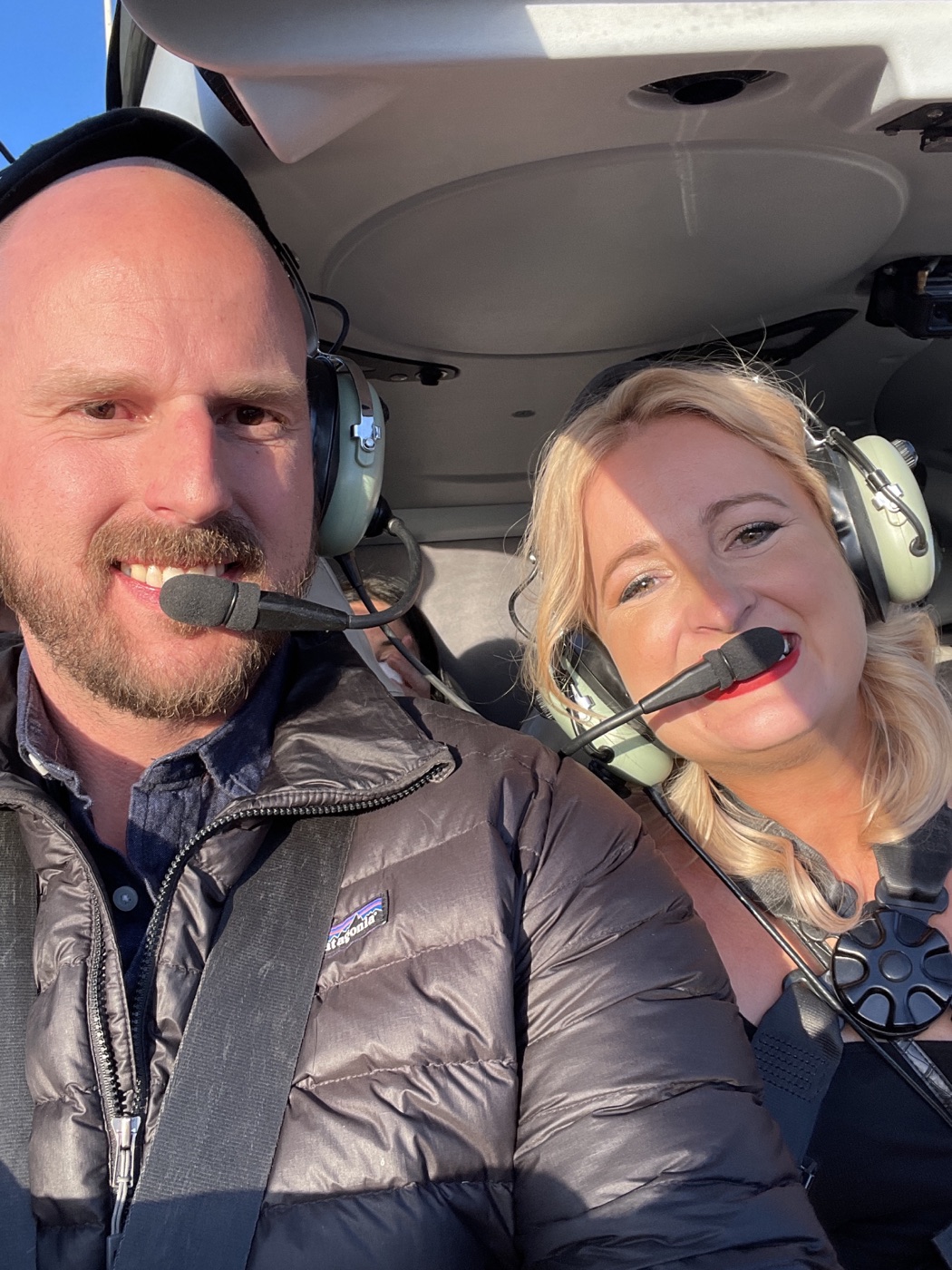 Jonathan and a passenger wearing aviation headsets in an aircraft