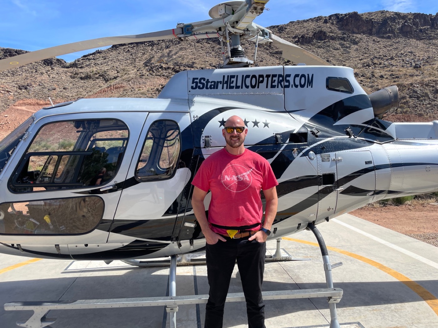 Jonathan beside a helicopter in the desert